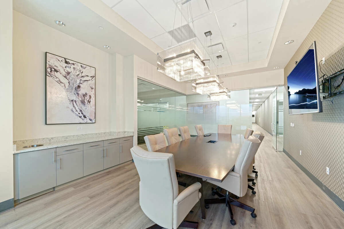 Another meeting room, surrounded by glass partitions, flaunts many of the office's modern fixtures.
