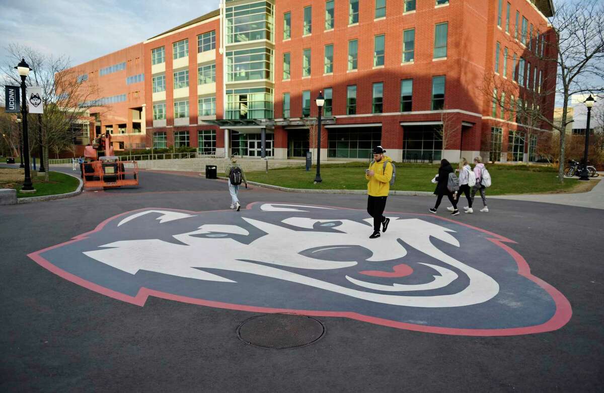 Students walk to class at the UConn campus in Storrs, Conn. Monday, April 4, 2022.