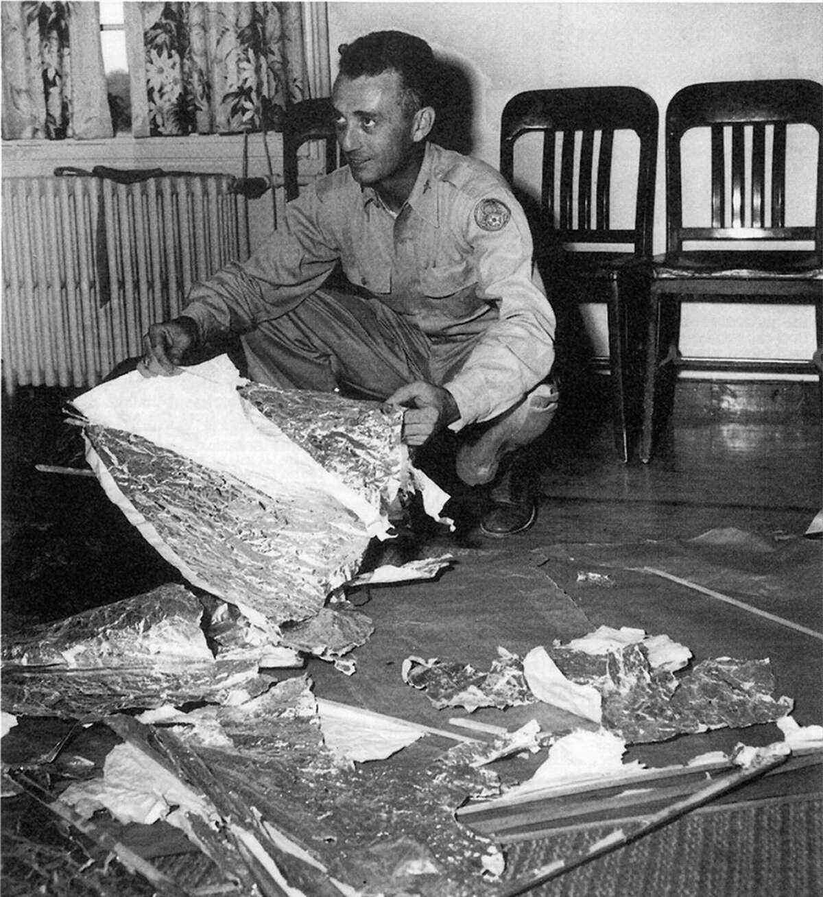 Fort Worth Army Air Field 8th July 1947: Jesse Marcel, head intelligence officer, who initially investigated and recovered some of the debris from the Roswell UFO site poses with debris. In mid-1947, a United States Air Force balloon crashed at a ranch near Roswell, New Mexico. Following wide initial interest in the crashed 'flying disc', the US military stated that it was merely a conventional weather balloon. (Photo by: Universal History Archive/ Universal Images Group via Getty Images)