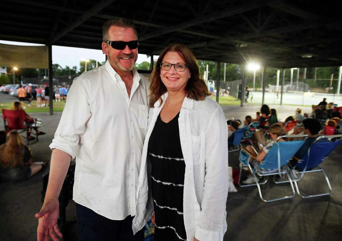 Brian Smith, left, and Tracy Bonosconi of the Downtown Milford Business Association kick off the outdoor summer movie night series at the Fowler Field Pavilion in Milford on Wednesday.