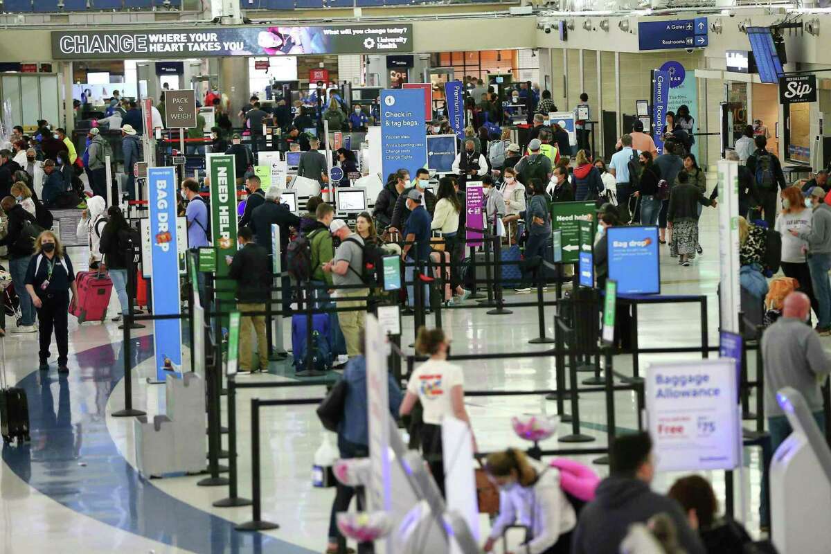 Travelers line up at airline ticket counters at San Antonio International Airport in March.