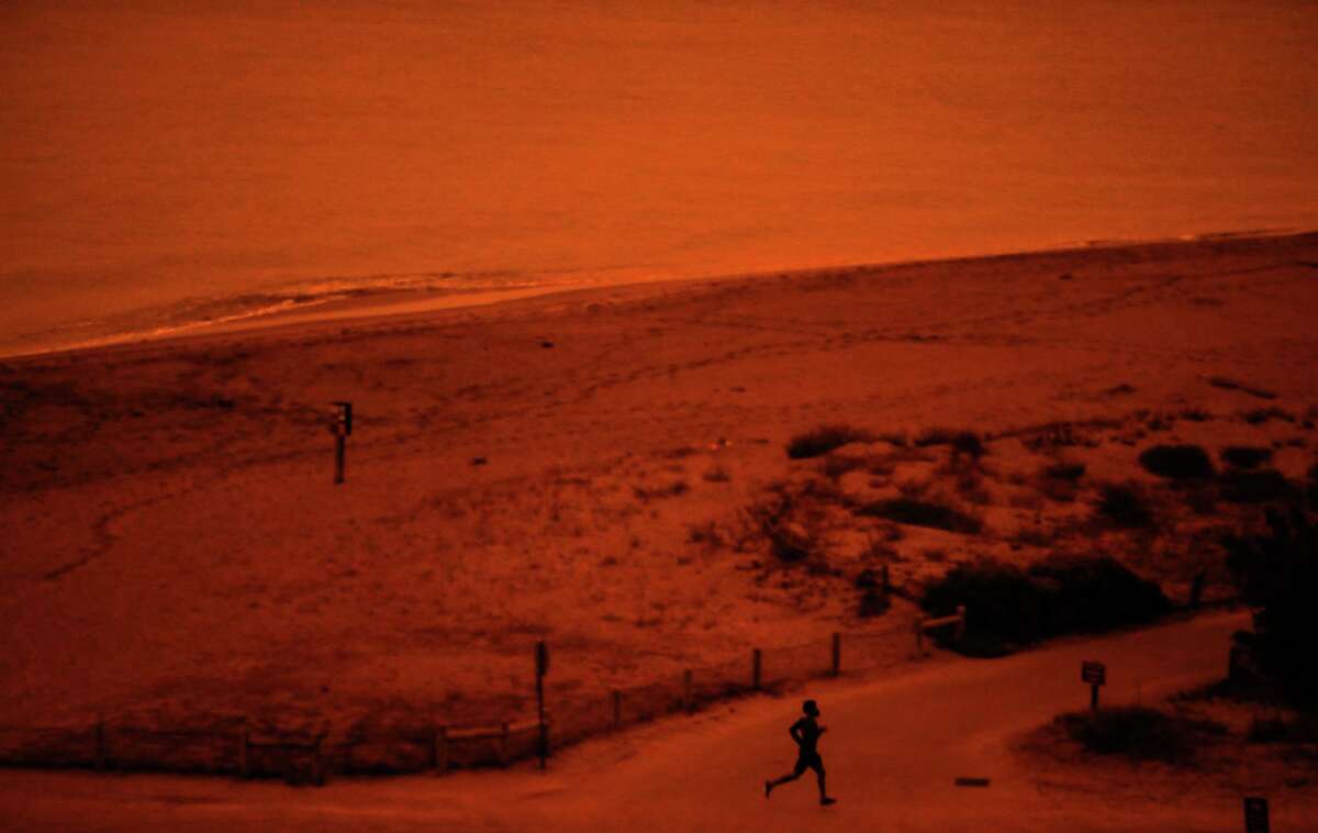 A runner braves the dark-orange smoke at Crissy Field in San Francisco as multiple wildfires burn across California and Oregon in 2020.