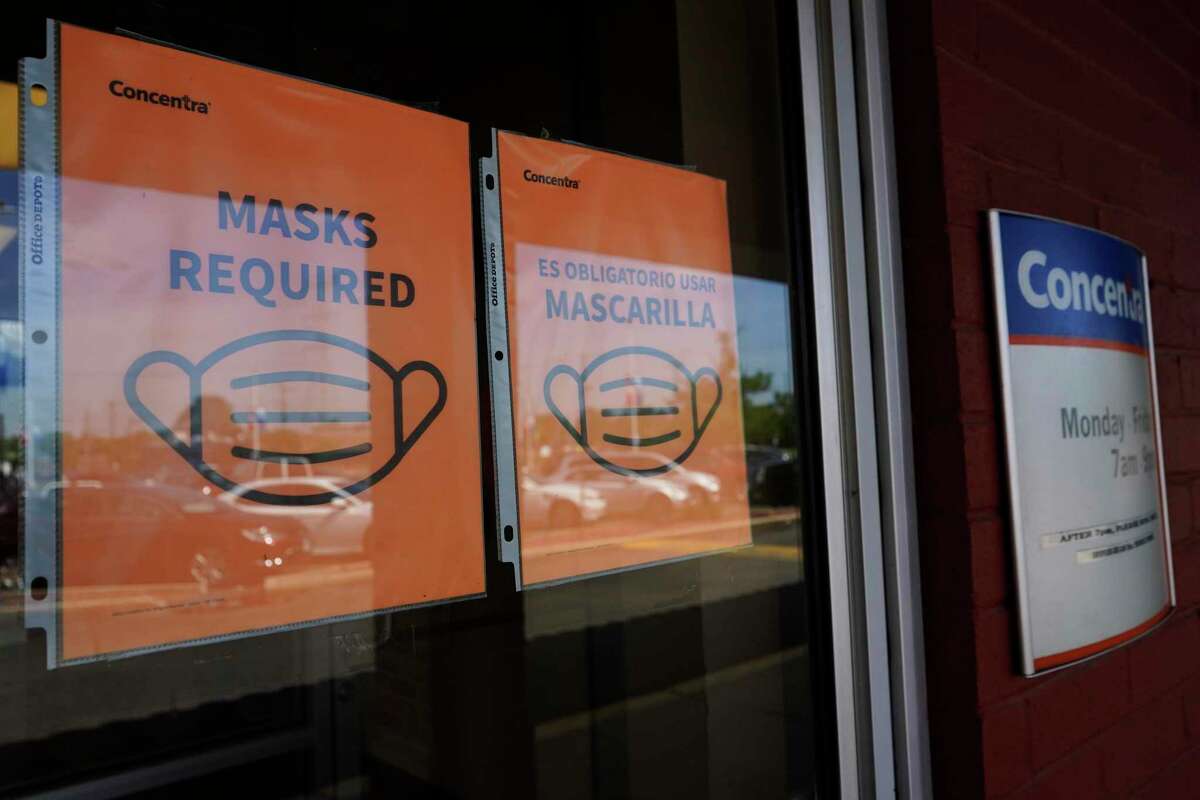 Masks required signs are displayed at Concentra Urgent Care in Wheeling, Ill., COVID-19 transmission. (AP Photo/Nam Y. Huh)