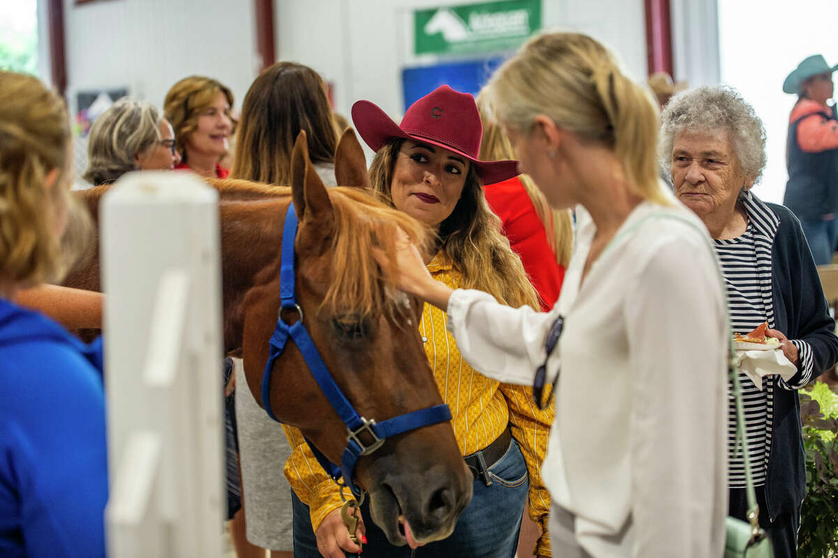 Lawrence resident Victoria Williamson lets people pet her horse, Cupcake, at the ribbon cutting of the Midland Fair Equestrian Center on July 8, 2022.