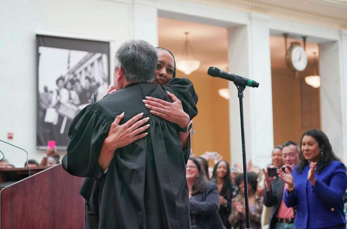 During her swearing-in at City Hall, new District Attorney Brooke Jenkins embraces Samuel Feng, presiding judge of San Francisco Superior Court.