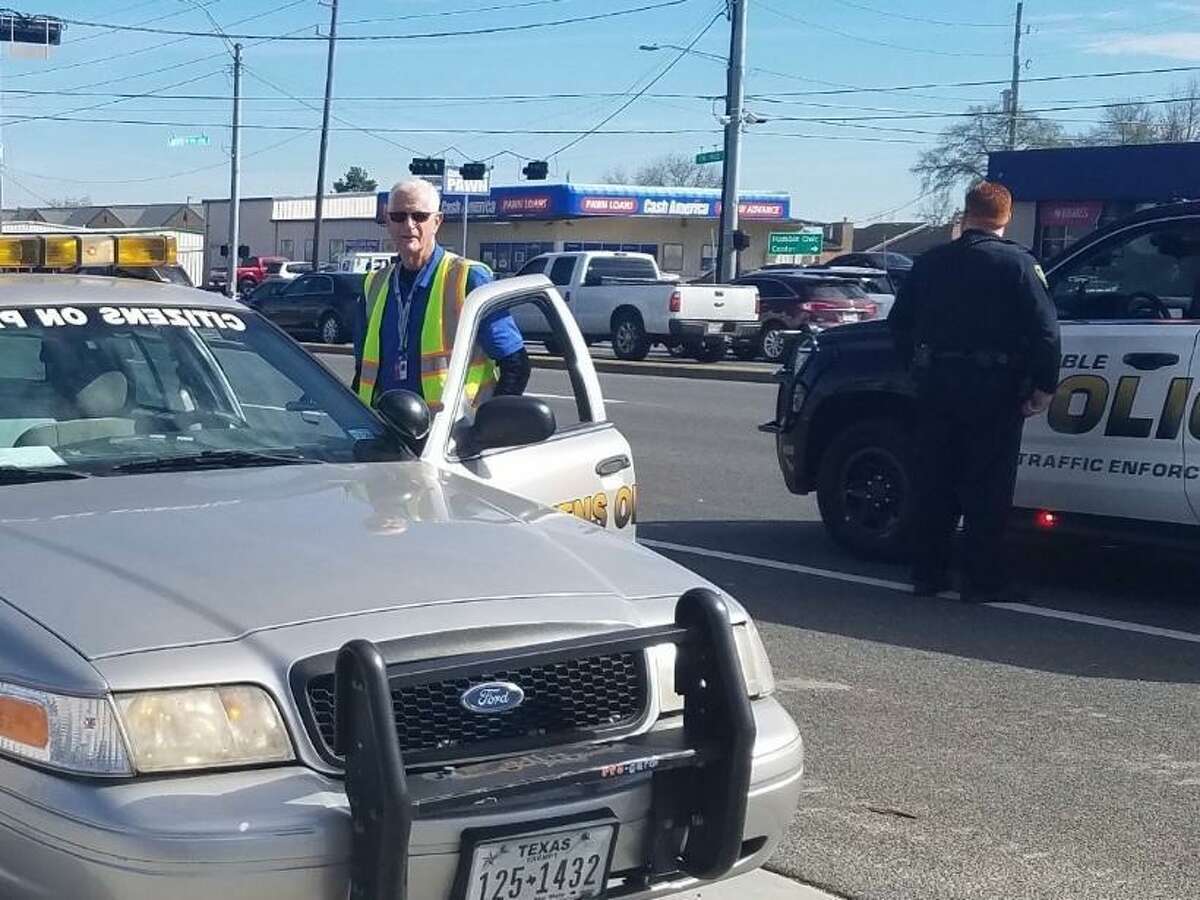 Dave with the Humble Citizens On Patrol helps an officer with traffic.