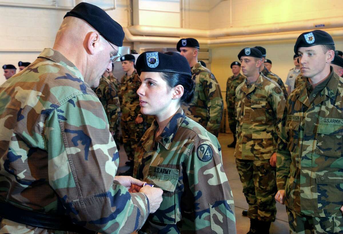 Maj. Gen. Dennis Laich left, commanding general of the 94th Regional Readiness Command, pins a Purple Heart on Army Reserve Specialist Heather Awner of Wallingford during a ceremony at the Army Reserve Center, New Haven, in 2004.