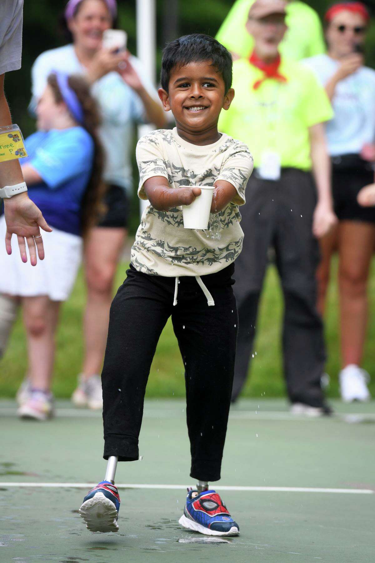 Arnav Sundeep, of Mountain Top, Pa., runs with a cup of water during a relay race at Camp No Limits, on Quinnipiac University’s York Hill Campus in Hamden.