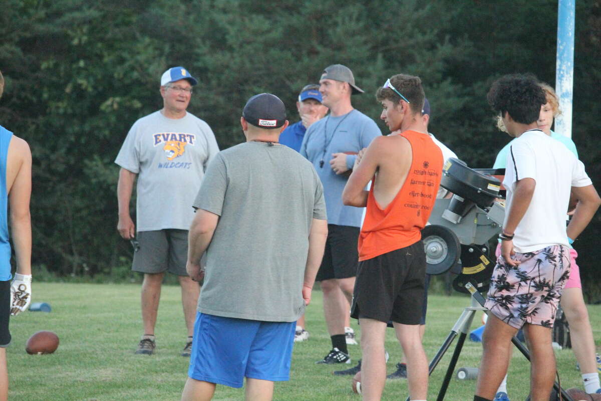 Evart coaches and players get ready to shoot footballs from out of a machine (at right) for receiving drills during a Thursday camp.