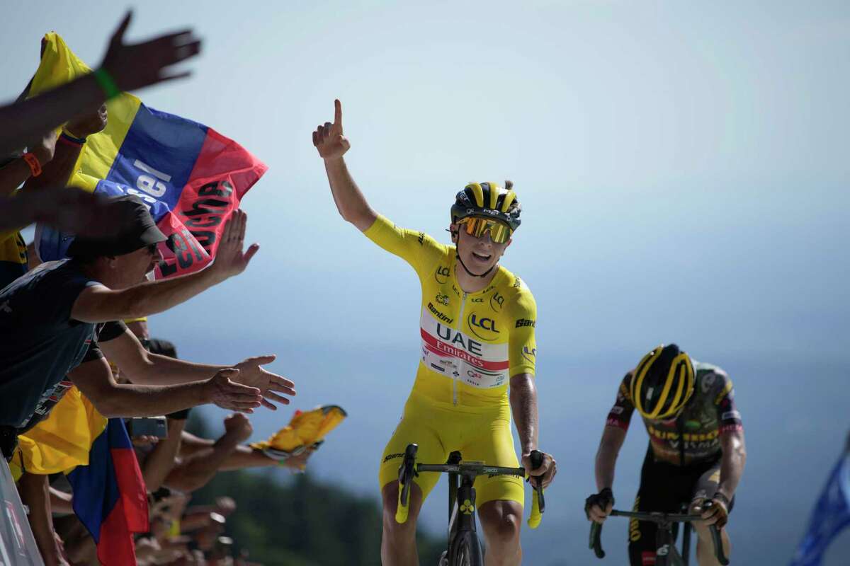 Slovenia's Tadej Pogacar, wearing the overall leader's yellow jersey, celebrates as he crosses the finish line to win the seventh stage of the Tour de France cycling race over 176.5 kilometers (109.7 miles) with start Tomblaine and finish in La Super Planche des Belles Filles, France, Friday, July 8, 2022. Denmark's Jonas Vingegaard finished second. (AP Photo/Daniel Cole)