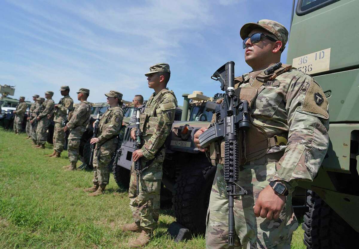 Texas Army National Guard troops stand by as Gov. Greg Abbott and other governors hold a press conference in Mission. Abbott on Dec. 16 told Defense Secretary Lloyd Austin he will not direct the guard to follow a COVID-19 vaccination order. (Joel Martinez/The Monitor via AP)
