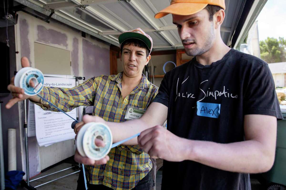 Andrea Lara (left), with Greywater Action, shows volunteer Alex Lunine how to tape a pipe fitting during a greywater installation demonstration at a Vallejo home.