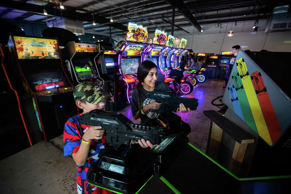 Gunner Skaggs, 11, and Natalia Medrano, 14, play at the arcade Cidercade in EaDo.