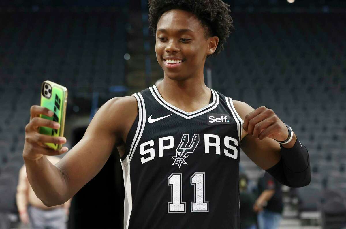 Spurs guard Josh Primo takes a selfie of him wearing his jersey with a new corporate logo by Self Financial as the San Antonio Spurs announce in a press conference their new partnership with the Austin-based financial technology company on Tuesday, June 21, 2022. The Spurs and the G-League Austin Spurs will sport the Self corporate logos on their jerseys this upcoming season.