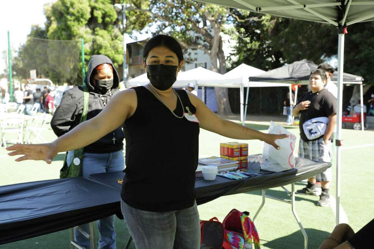 Xochtil Larios directs volunteers in the Kid Zone tent Friday during a Town Nights event in Oakland.