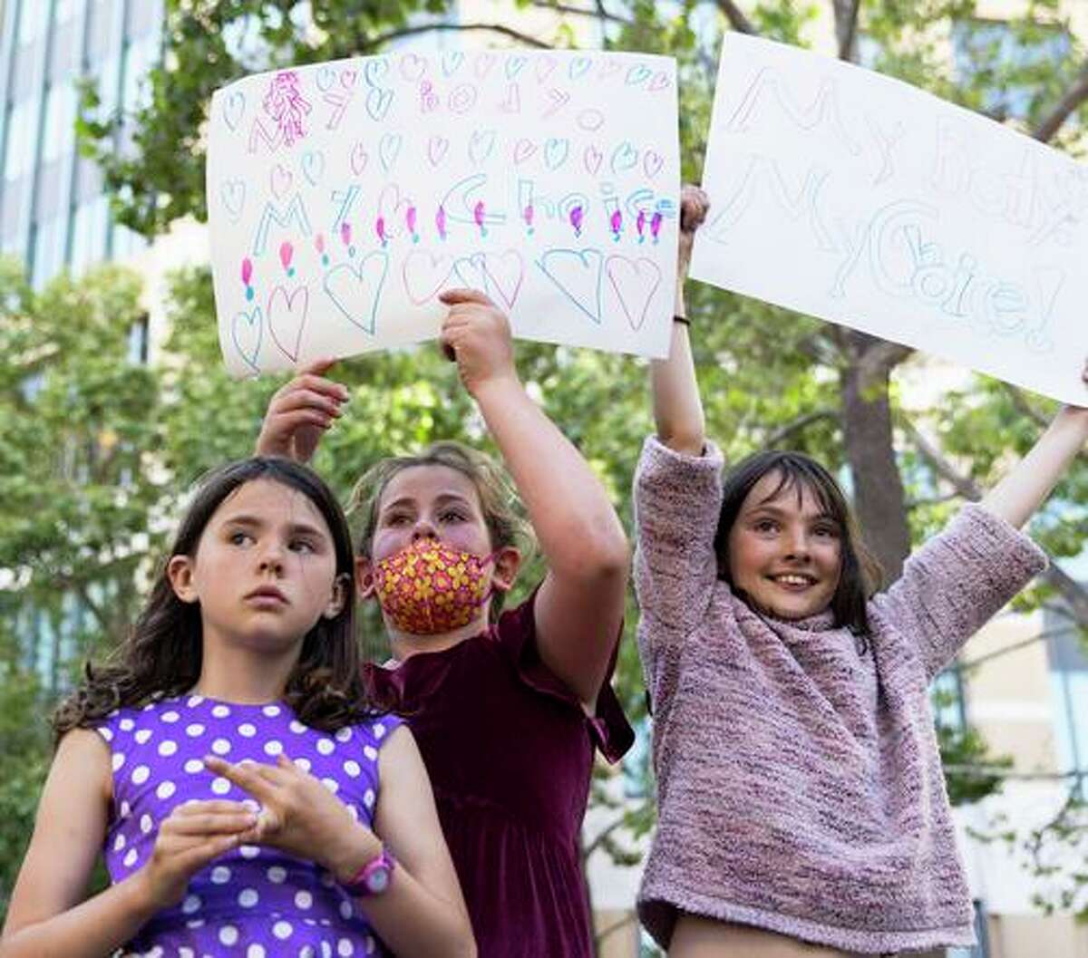 Imogen McRae, 8 (left), Aviva Shapiro, 9, and Saskia McRae, 10, protest at the Dellums Federal Building in Oakland in May.