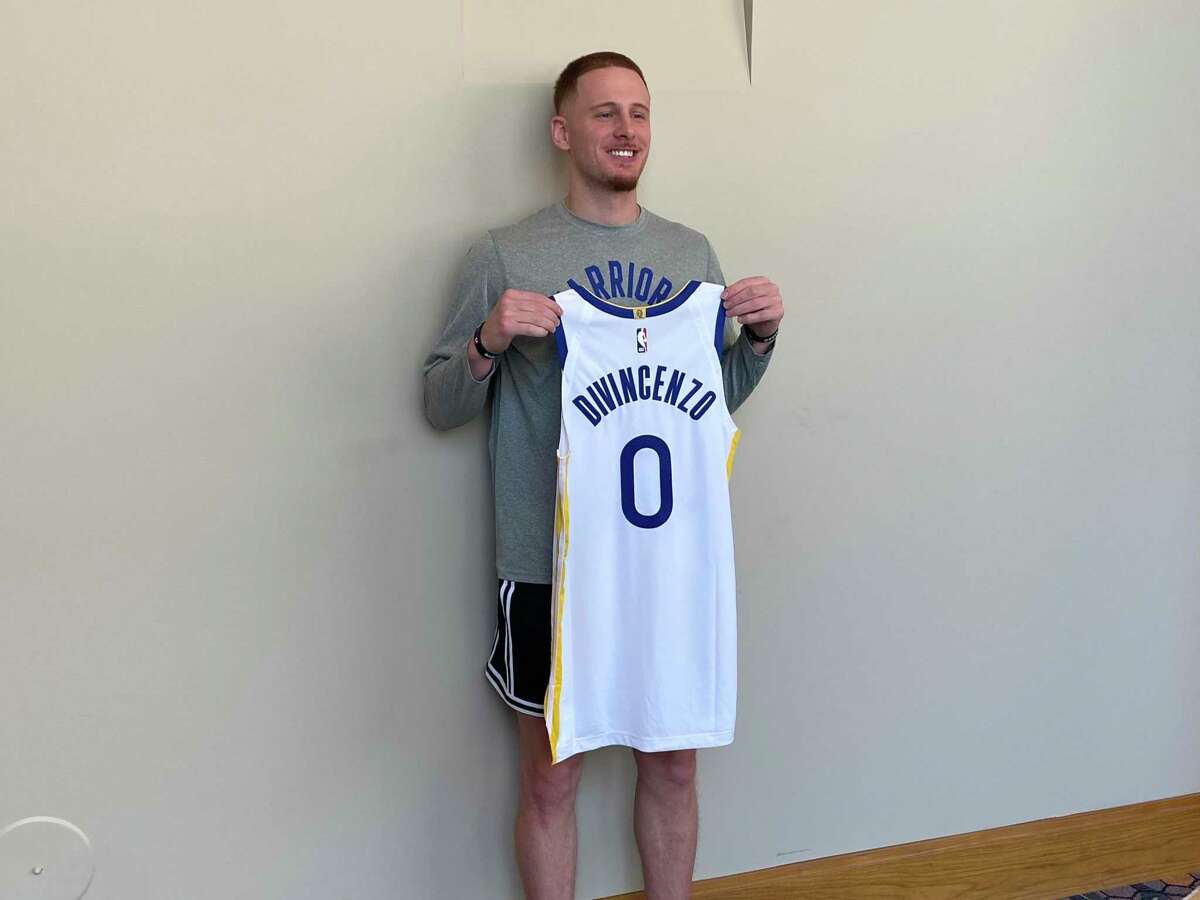 Donte DiVincenzo holds up his new Golden State Warriors jersey at his introductory news conference on Saturday, July 9, 2022, in Las Vegas.