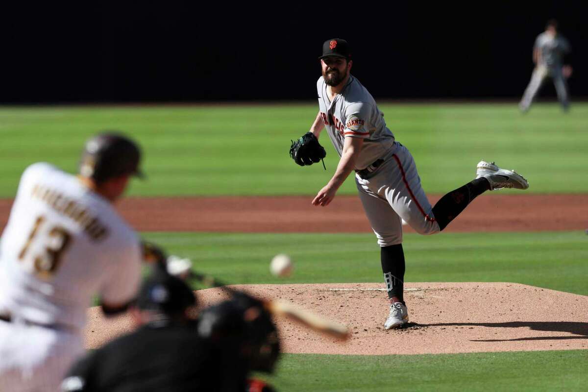 San Francisco Giants starter Carlos Rodon, right, follows through on a pitch to San Diego Padres' Manny Machado in the first inning of a baseball game Saturday, July 9, 2022, in San Diego. (AP Photo/Derrick Tuskan)