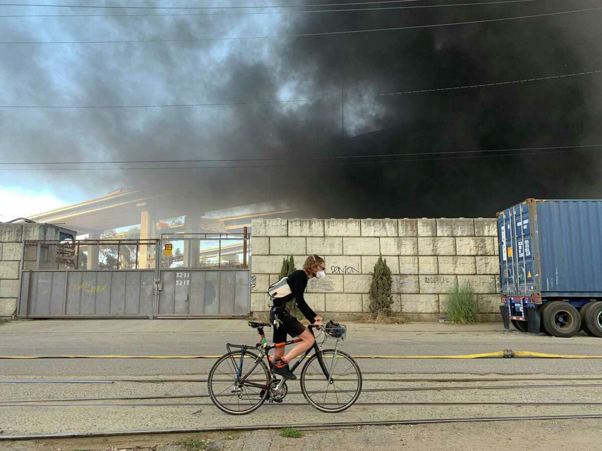 一股巨大的烟雾从伍德街升起，是由一个营地的大火引起的。奥克兰消防局在现场。