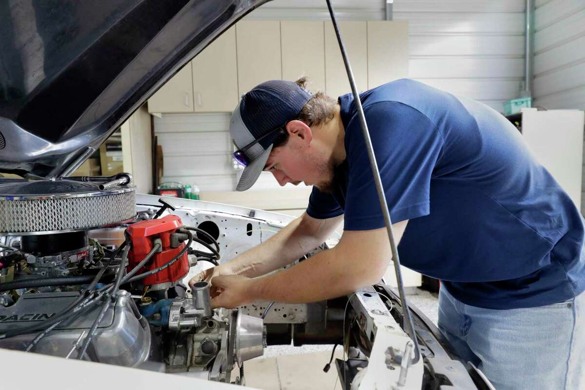 Colton Lowe works on a thermostat housing for the 90s era Mustang he is rebuilding at his home garage in Conroe.