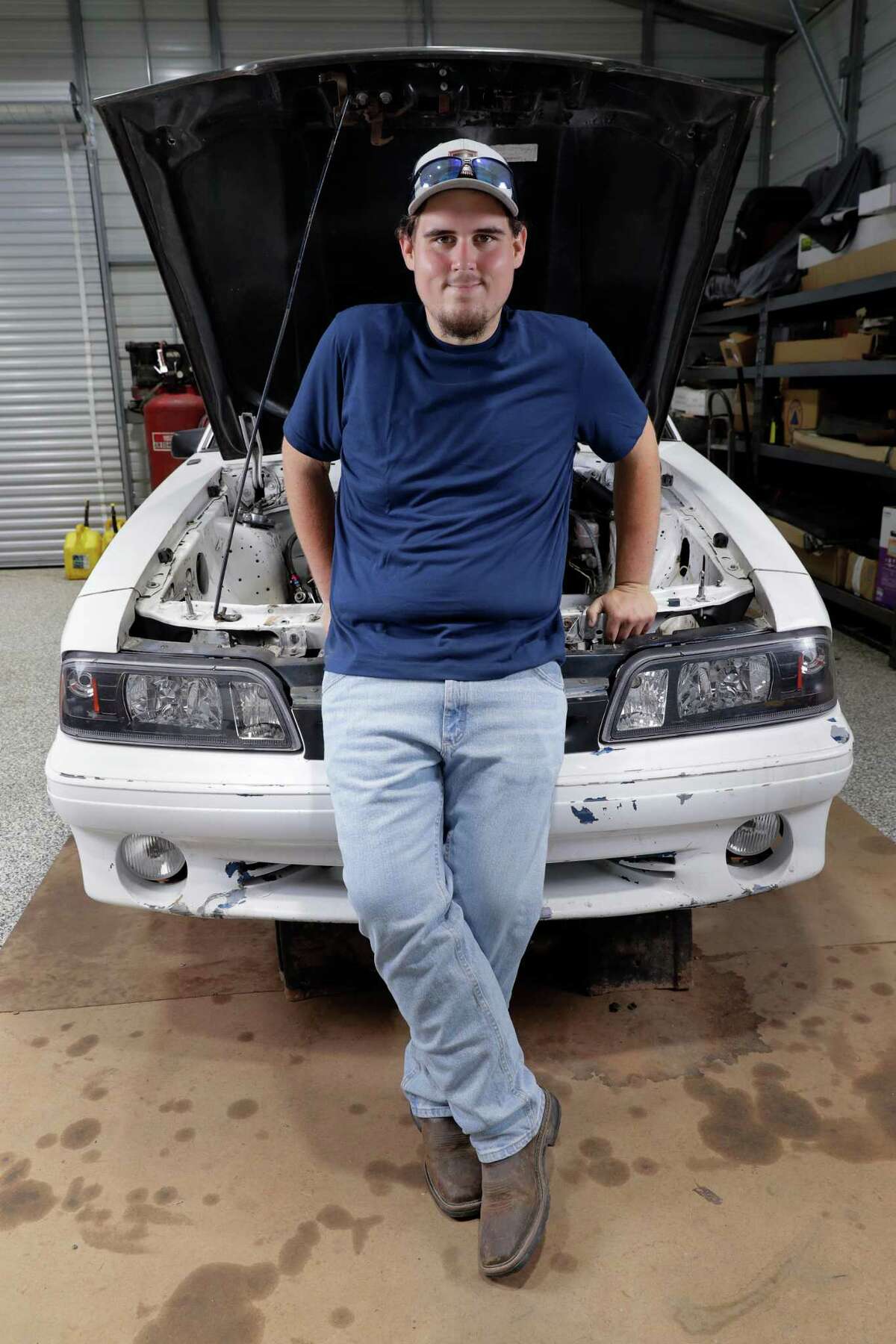 Colton Lowe, who formerly weighed 400 pounds, with his 90s era Mustang at his home garage in Conroe. Lowe bought the car, but could not fit inside, which prompted him to undergo bariatric surgery.