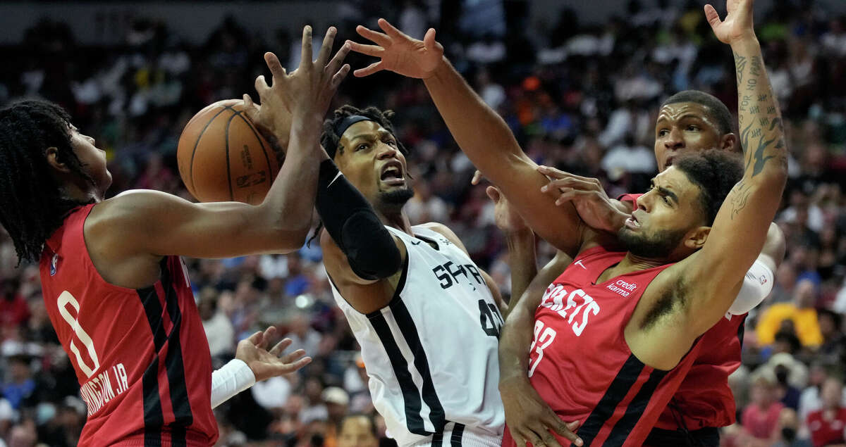 From left, Houston Rockets' TyTy Washington Jr., San Antonio Spurs' Javin DeLaurier, Houston Rockets' Anthony Lamb and Jabari Smith Jr. battle for a rebound during the second half an NBA summer league basketball game Monday, July 11, 2022, in Las Vegas. (AP Photo/John Locher)