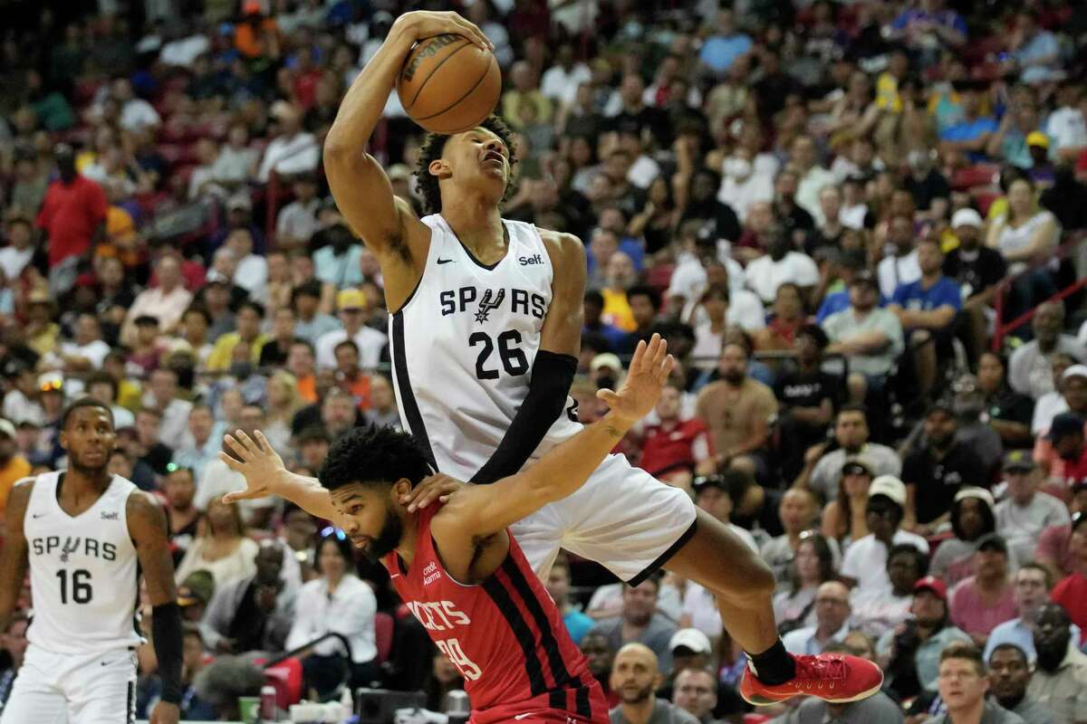 San Antonio Spurs' Dominick Barlow grabs a rebound over Houston Rockets' Trevor Hudgins during the second half an NBA summer league basketball game Monday, July 11, 2022, in Las Vegas. (AP Photo/John Locher)