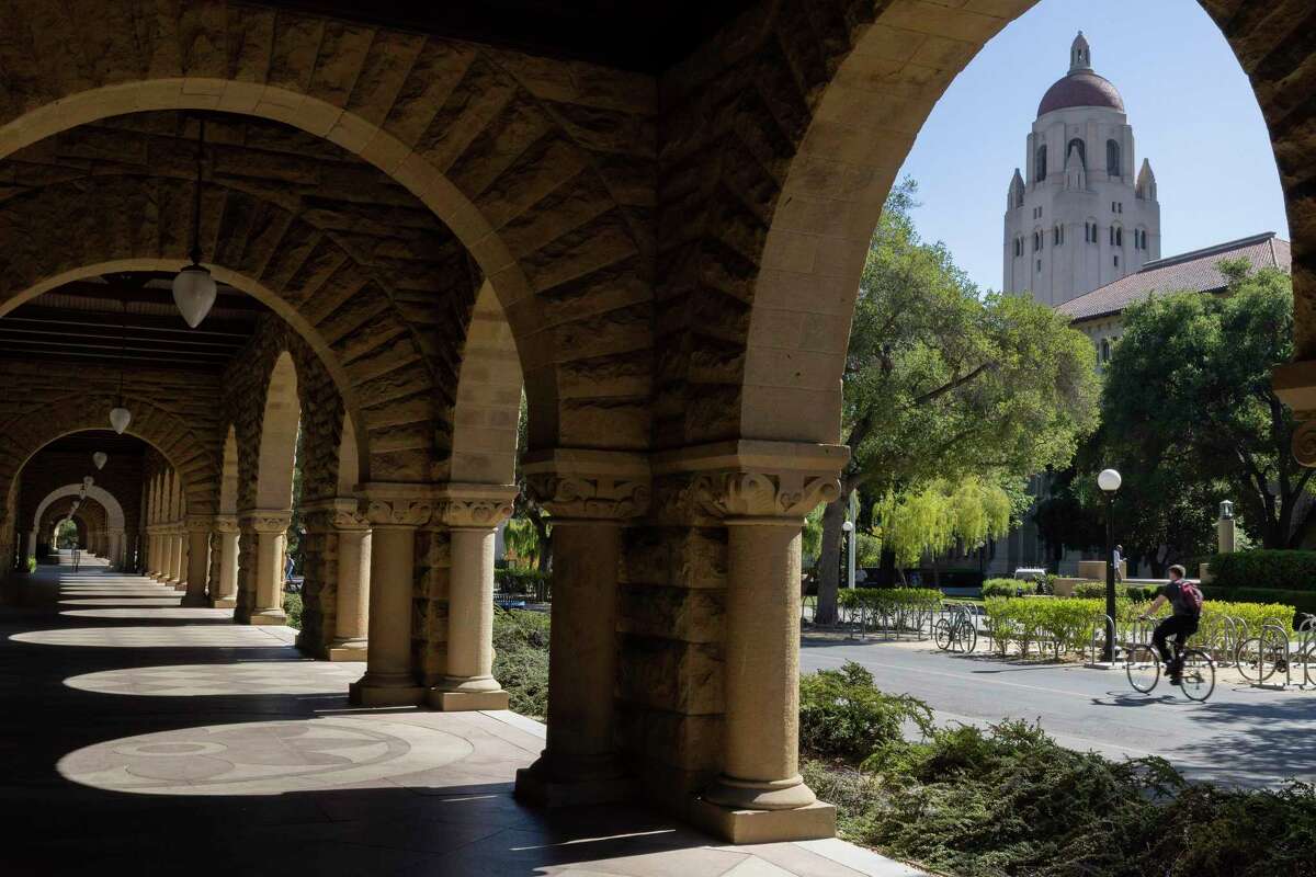 A cyclist rides through the campus of Stanford University in June, 2022. The renowned school is beginning 2023 shadowed by a series of tragedies and calamities from last year that raised troubling questions about its culture and policies.