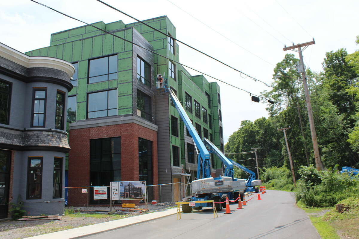 Construction workers place siding on the Newbury Hotel on July 11 in Coxsackie. Some work was permitted this month after a stop-work order was lodged in March.