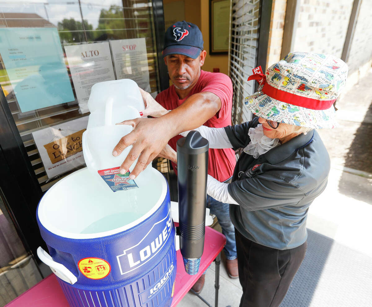Nick Garcia, center, helps Salvation Army staff member Deborah Wright refill a water cooler at the organizationâs cooling station as temperatures creep into the triple digits, Thursday, June 9, 2022, in Conroe. Hot and sunny summertime weather remains the theme through the weekend in Montgomery County, with high temperatures reaching 100 degrees for much of the area, according to Space City Weather.