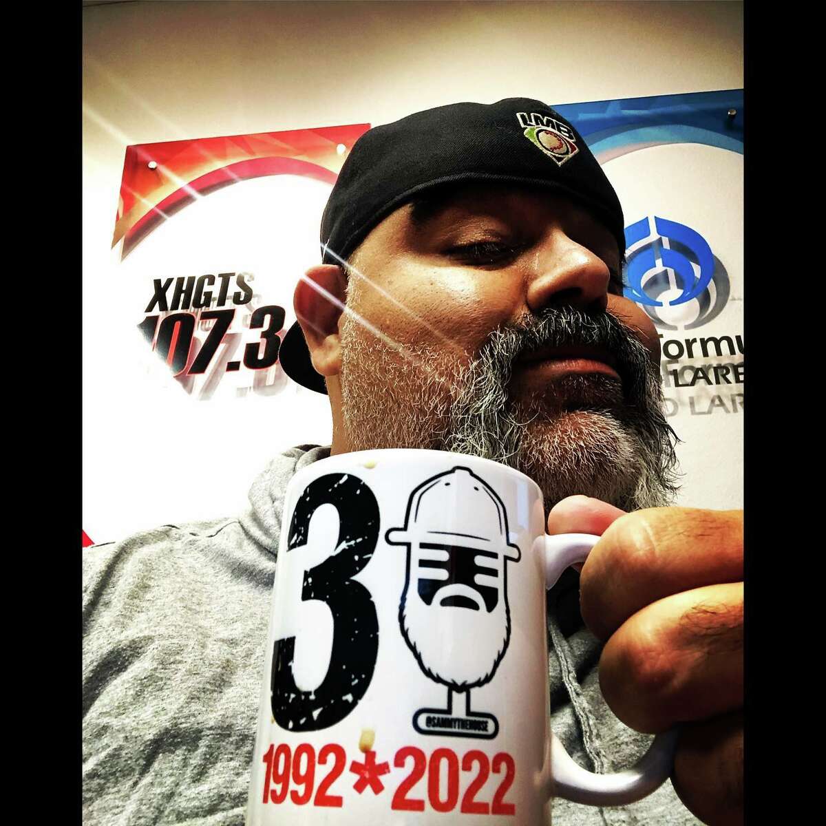 DJ Sammy the House is pictured with a mug celebrating his 30 years on the air on Laredo airwaves. 