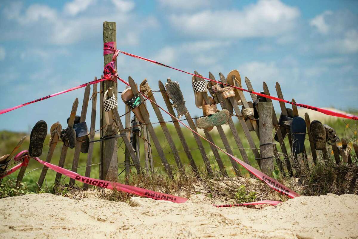 Sandals rest on a fence that was put up to try and build up dunes along the beach, on May 11, 2022, in Jamaica Beach on Galveston Island.