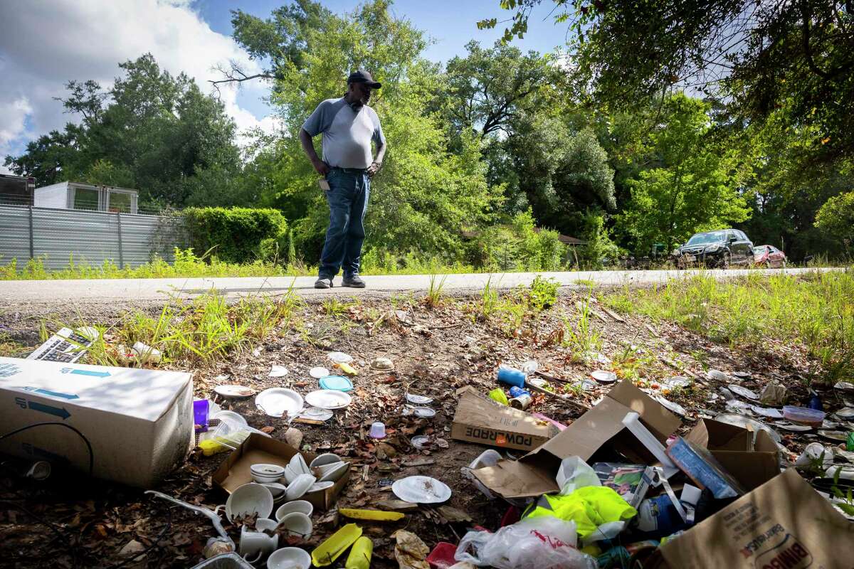 Raymond Dugas surveys a large pile of trash left by people across the street from his property northeast of downtown Houston on Friday, July 8, 2022. Dugas says people have been using the space for illegal dumping for years.