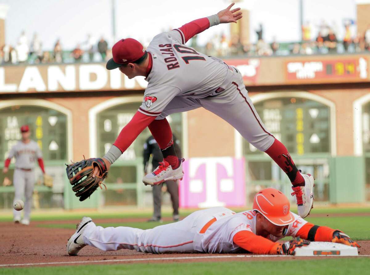 David Villar (70) safe at third as the ball gets away from Josh Rojas (10) after Villar hit a two-rbi triple and scored on the throwing error in the first inning as the San Francisco Giants played the Arizona Diamondbacks at Oracle Park in San Francisco, CA, Calif., on Tuesday, July 12, 2022.