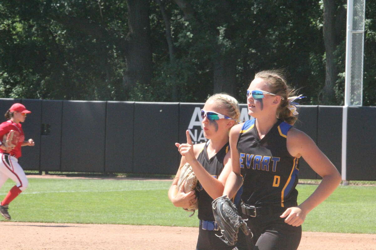 Evart's Skylar Baumgardner (right) comes off the field after making a stellar play at the softball state finals.