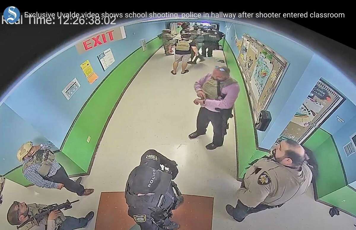 In this photo from surveillance video provided by the Uvalde Consolidated Independent School District via the Austin American-Statesman, authorities stage in a hallway as they respond to the shooting at Robb Elementary School in Uvalde, Texas, Tuesday, May 24, 2022. (Uvalde Consolidated Independent School District/Austin American-Statesman via AP)