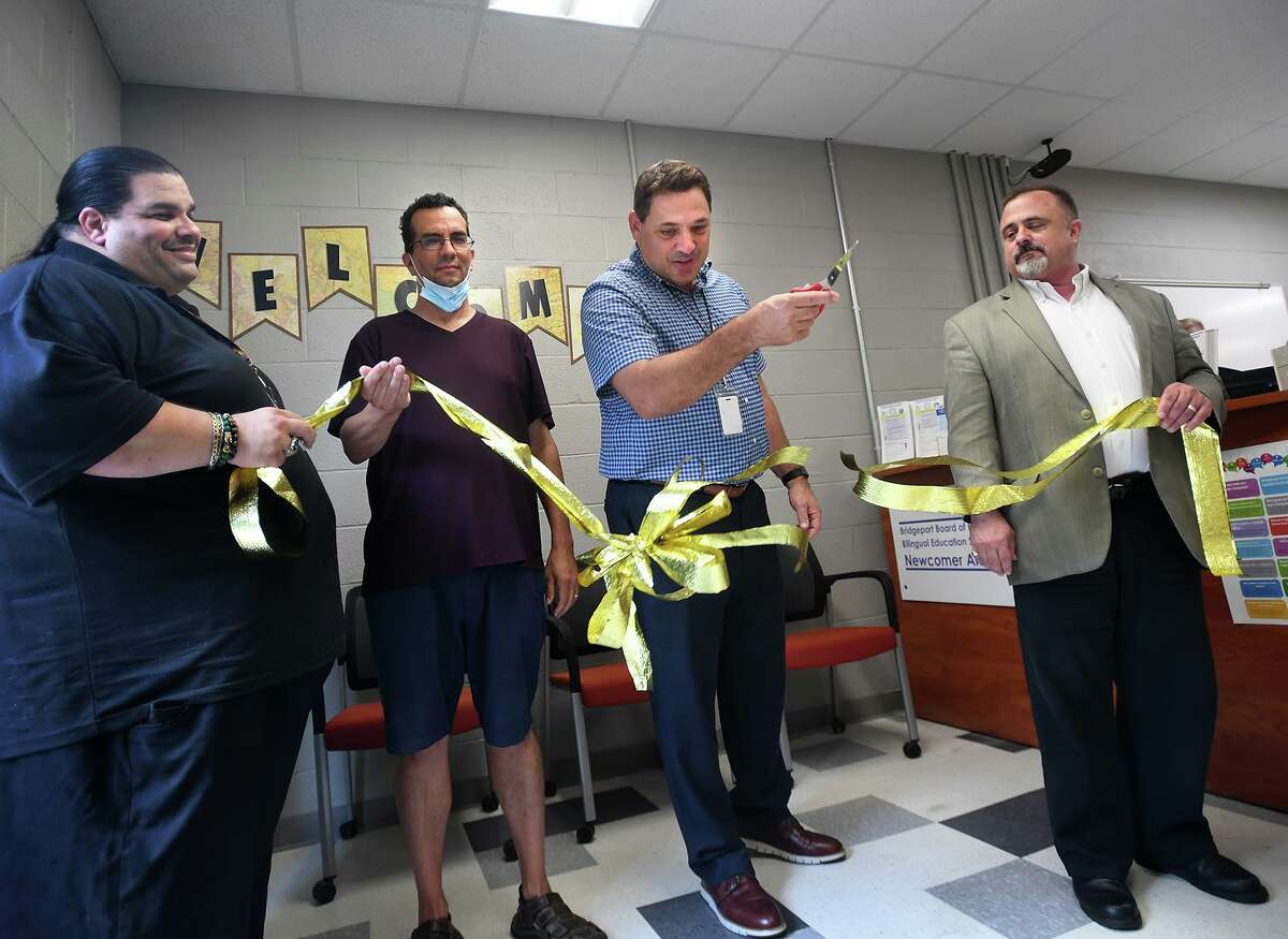Bridgeport Superintendent of Schools Michael Testani cuts the ribbon on the Board of Education's Newcomer Arrival Center at Central High School in Bridgeport, Conn. on Tuesday, August 10, 2021. From left are board members Albert Benejan Grajales, Joe Sokolovic, Testani, and John Weldon.