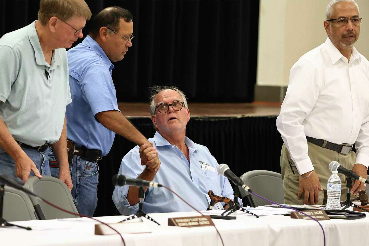 Uvalde Mayor Don McLaughlin (sitting) greets members of the city council as they meet on Tuesday, July 12, 2022 before a group of families and friends of victims in the Robb Elementary mass shooting to discuss the next steps in replacing Pedro “Pete” Arredondo, the embattled school district police chief who resigned his council seat over the Independence Day weekend. The council and residents also reacted to a leaked video of the school shooting - with some expressing strong resentment about the leaked footage.