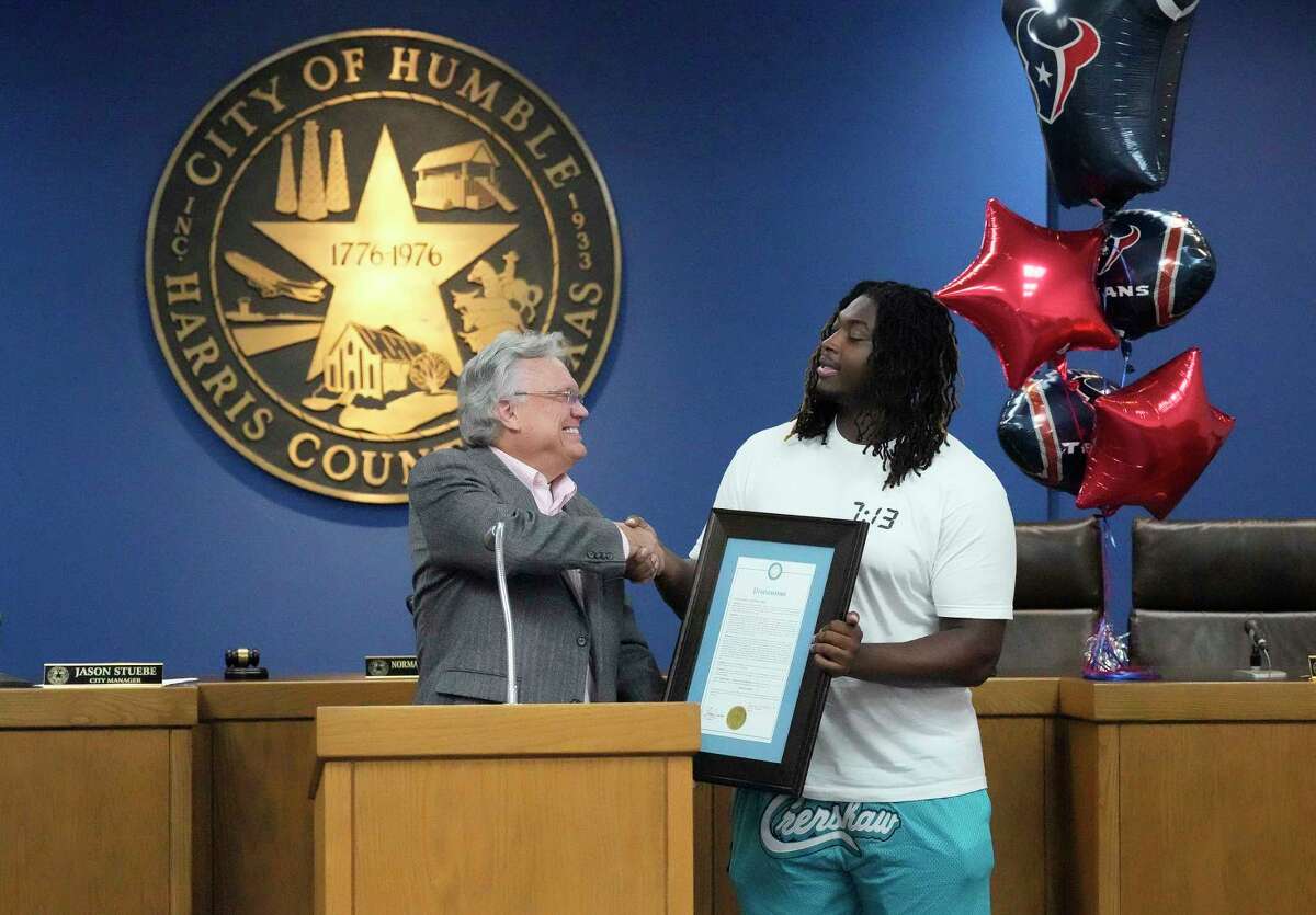 Humble Mayor Norman Funderburk shakes hands with Texans rookie offensive lineman Kenyon Green after reading a declamation that made July 13 “Kenyon Green Day” on Wednesday at Humble City Hall.