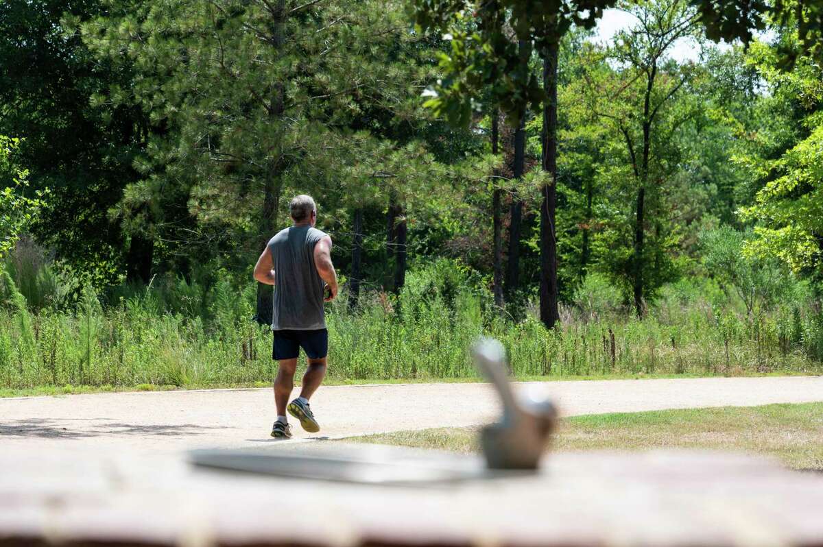 A man jogs past a water fountain at Memorial Park Monday, July 11, 2022, in Houston.