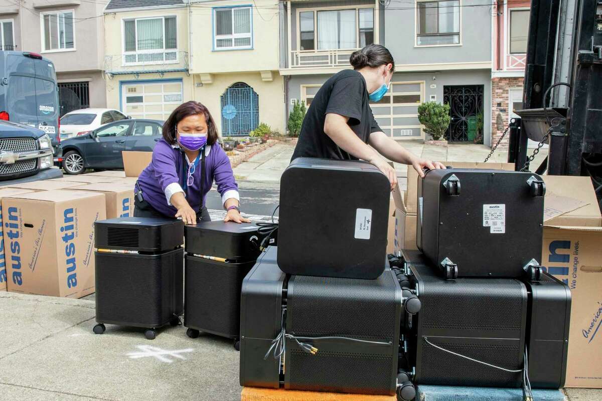 School principal Diane Lau Yee (left) and delivery person Ronnie Wehr move air purifiers with medical grade HEPA technology into Robert Louis Stevenson Elementary School in San Francisco in September 2021.