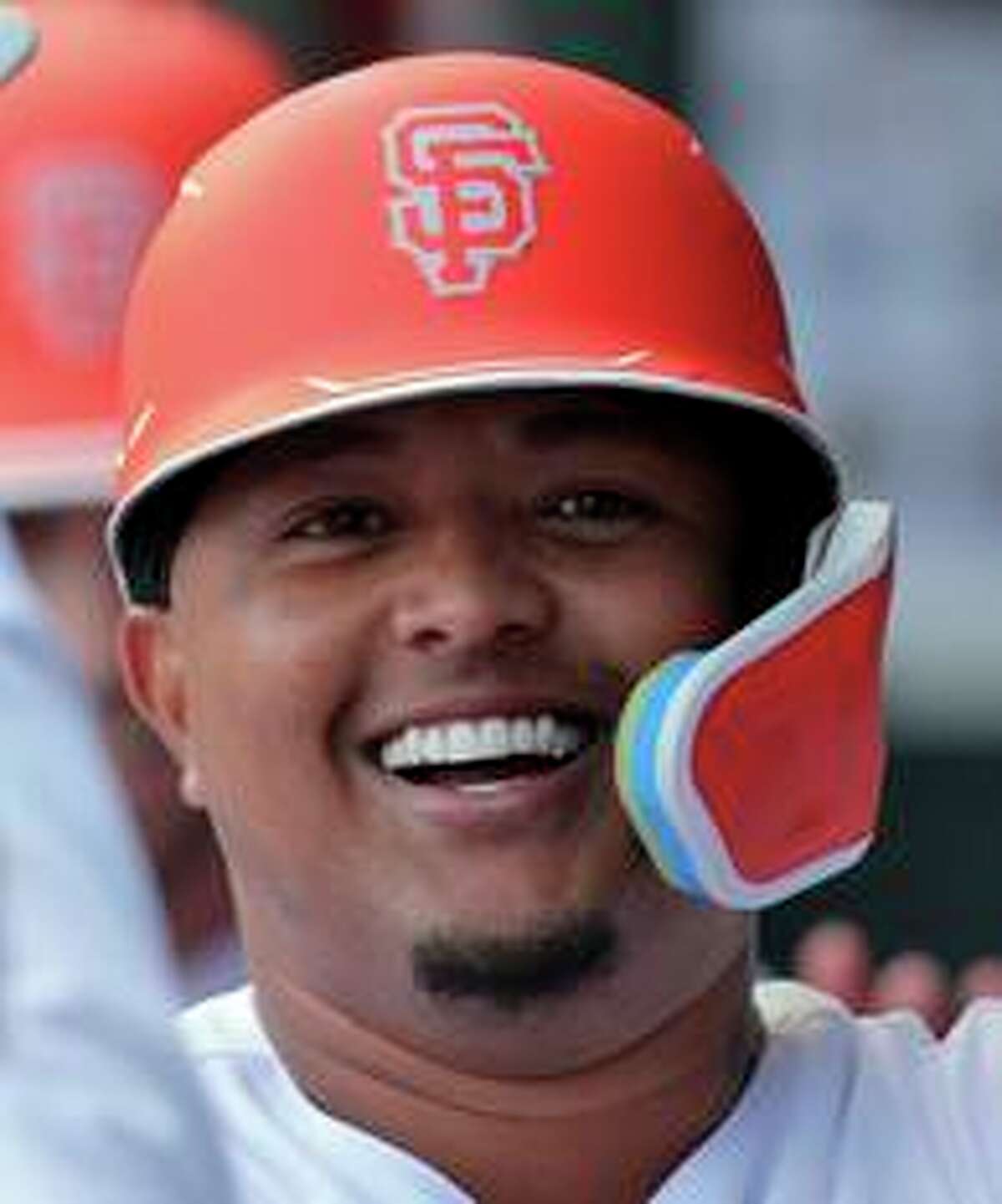 Yermin Mercedes smiles in the dugout as Giants teammates congratulate him following his two-run HR in Tuesday’s blowout win at Oracle Park.
