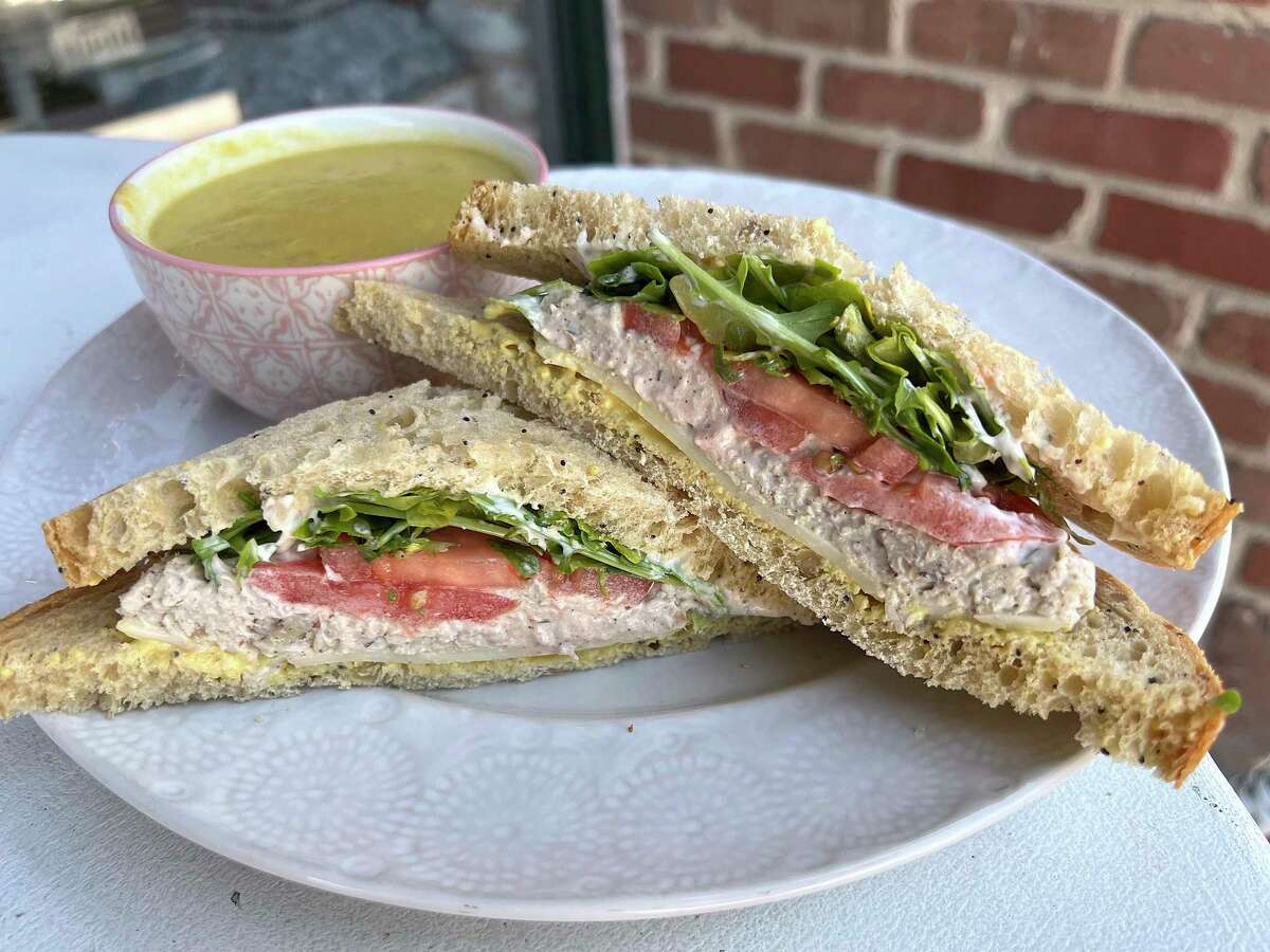 A tarragon chicken salad sandwich includes havarti cheese, arugula, tomato, mayo and Dijon mustard on seeded bread at Bird Bakery in Alamo Heights. Yellow squash corn chowder can be subbed for potato chips for an additional cost.