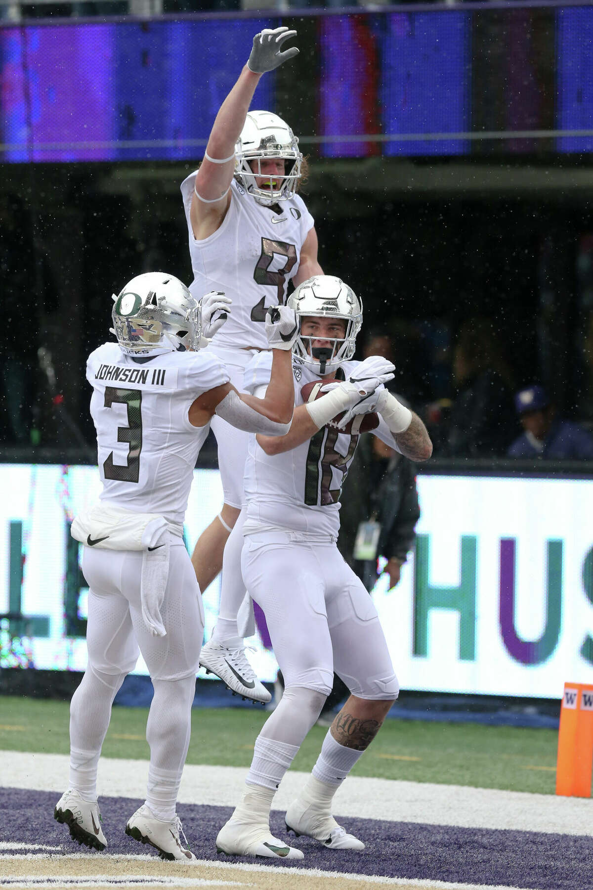 Oregon's (9) Brenden Schooler (WR) and (3) Johnny Johnson III (WR) celebrate with (18) Spencer Webb (TE) after he scored a touchdown during the college football game between the Washington Huskies and the Oregon Ducks on October 19, 2019 at Husky Stadium in Seattle, WA. 