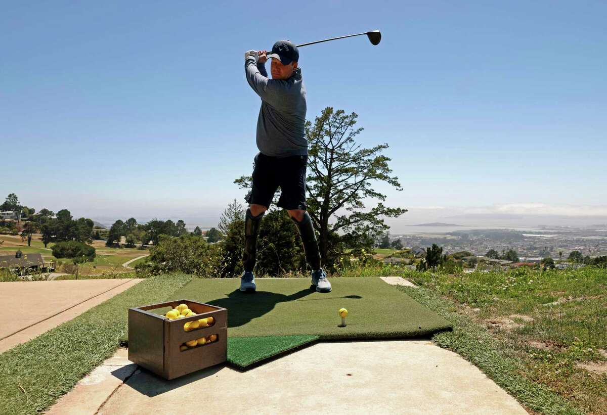 Golfer Erik Bowen, 42, practices his swing at Berkeley Country Club on Friday, July 1, 2022, in El Cerrito, Calif. Bowen is a double-amputee who qualified for the inaugural U.S. Adaptive Open, an international tournament for disabled golfers July 18-20 in Pinehurst, North Carolina. Bowen, who lives in Oakland, lost both of his feet in 2014 when he went into septic shock after having strep throat and pneumonia.