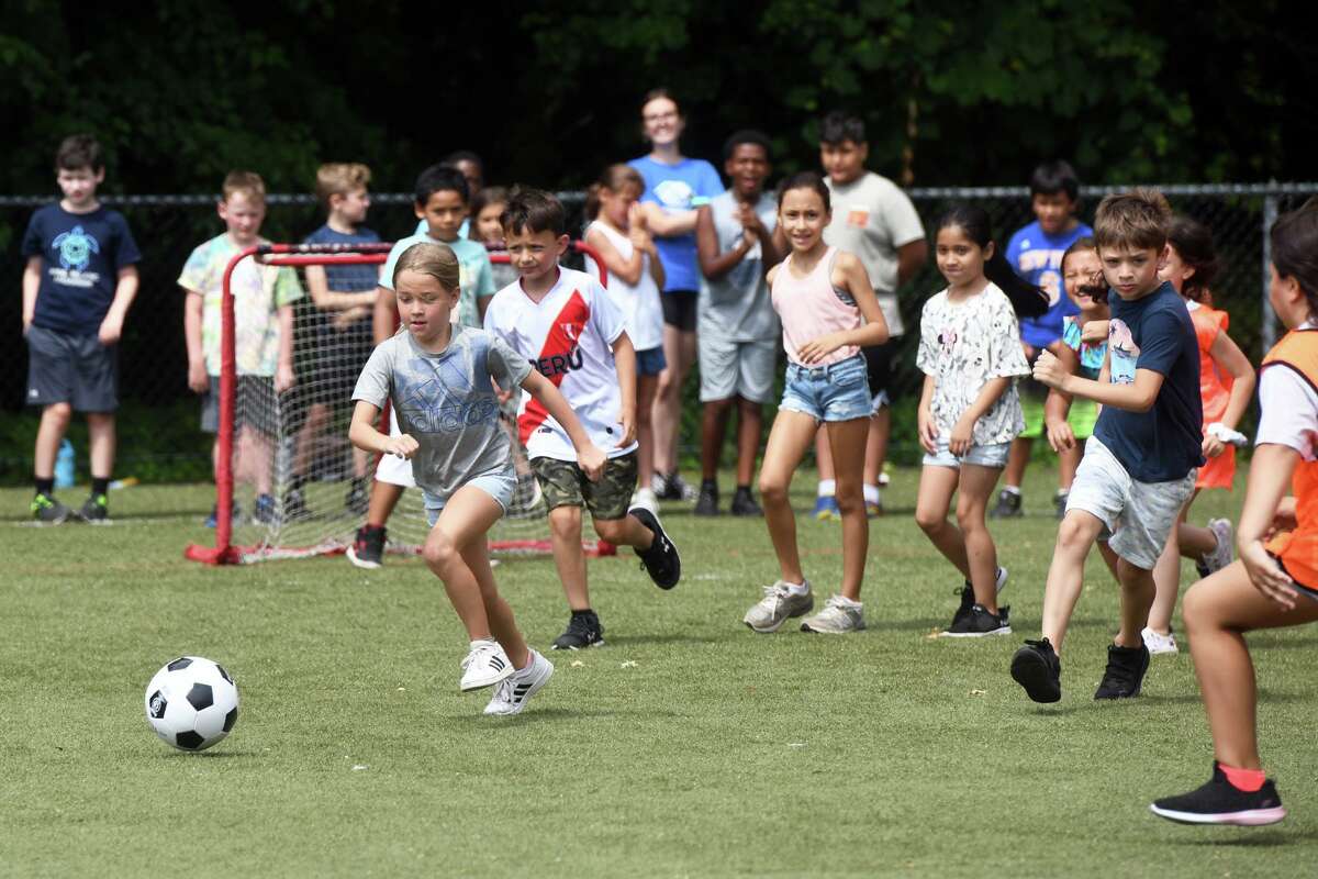 Kids play soccer during a health, wellness and soccer day camp at Wakeman Boys & Girls Club, in Fairfield, Conn. July 14, 2022.