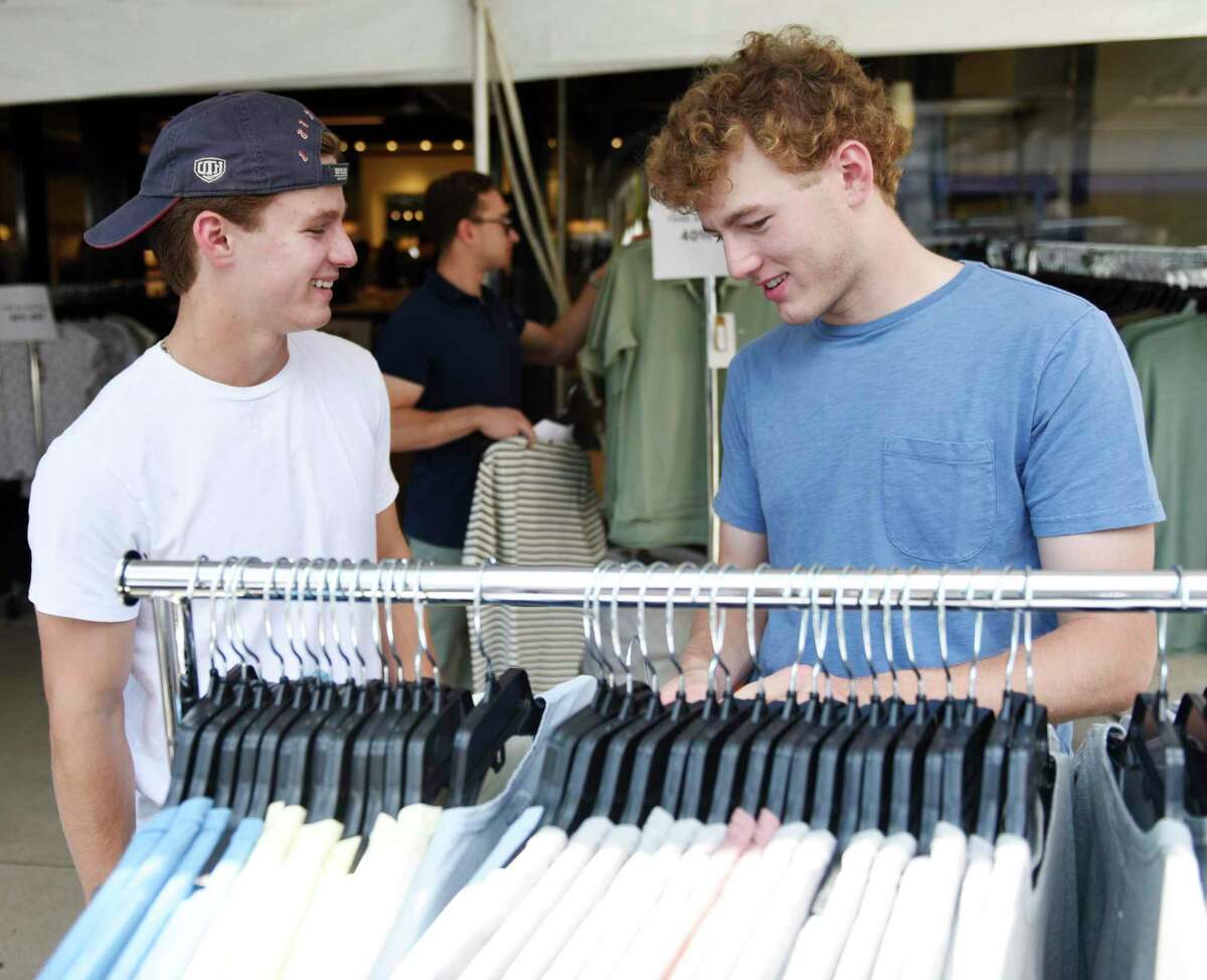 Greenwich's Wesley Zolin, left, and Charlie Zolin shop at Rag & Bone during the 2022 Sidewalk Sales in Greenwich, Conn. Thursday, July 14, 2022. Presented by the Greenwich Chamber of Commerce, dozens of businesses participated in the sale by displaying their goods on the sidewalk at heavily marked-down prices. The sales continue July 15 and 16 from 9 a.m. to 7 p.m., and July 17 from 9 a.m. to 5 p.m.