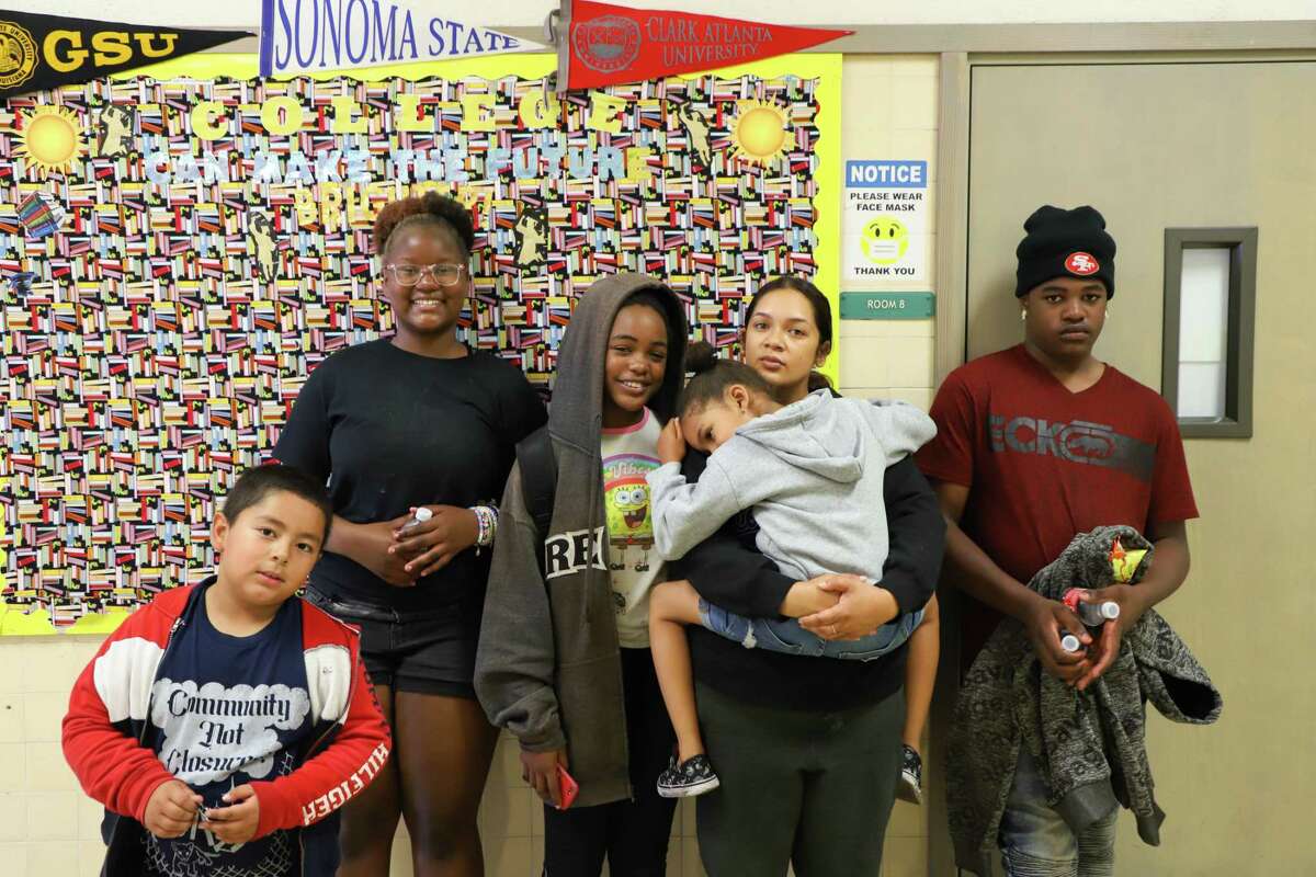 Azlinah poses for a portrait with students at Parker Elementary in July in Oakland. Azlinah is one of the parents who fought to keep Parker Elementary open.