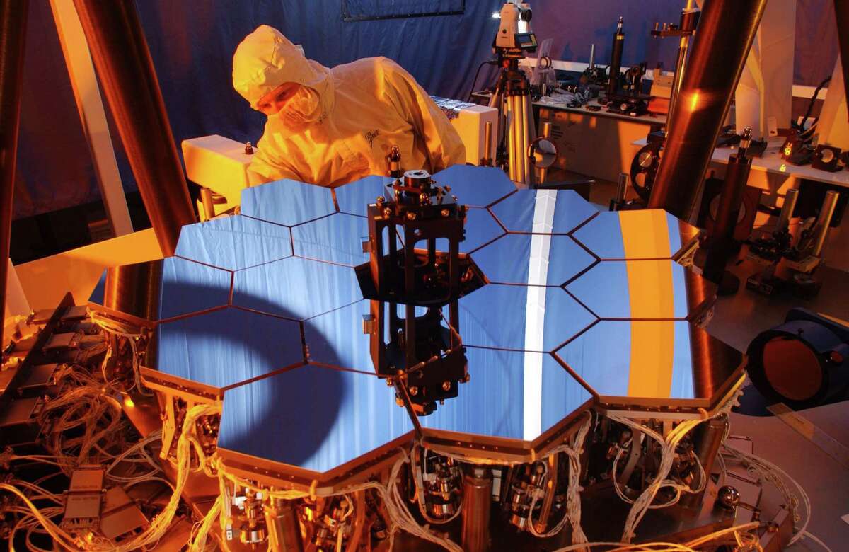 A Ball Aerospace engineer inspects the James Webb Space Telescope testbed telescope. As the principal subcontractor for Northrop Grumman Corporation, Ball Aerospace is contributing the advanced optical technology and lightweight mirror system for JWST. (PRNewsFoto/Ball Aerospace & Technologies Corp.)