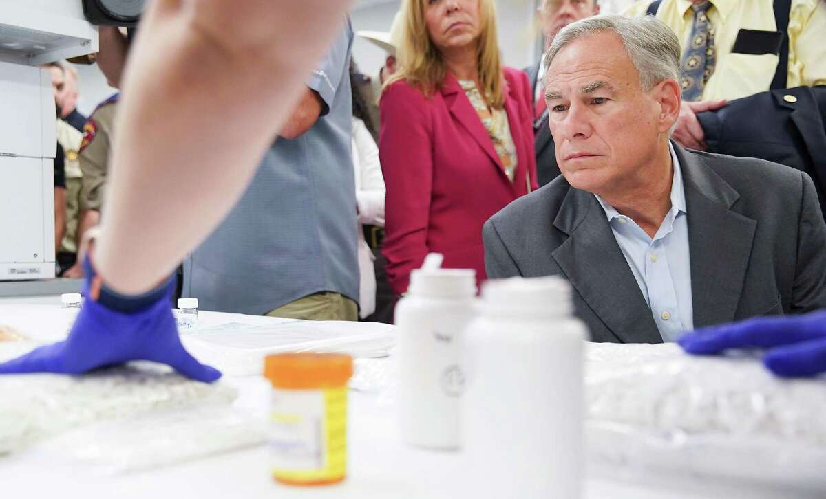 Texas Gov. Greg Abbott looks on as DPS Seized Drug System Trainer Jennifer Hatch points out drugs laced with fentanyl during a tour of the facility with on Thursday, July 14, 2022 in Houston.